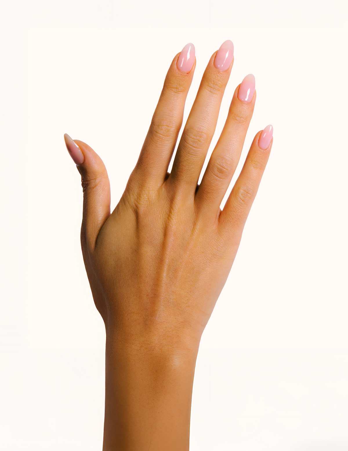 A close-up of a hand with neatly manicured, glossy light pink fingernails, set against a solid white background.